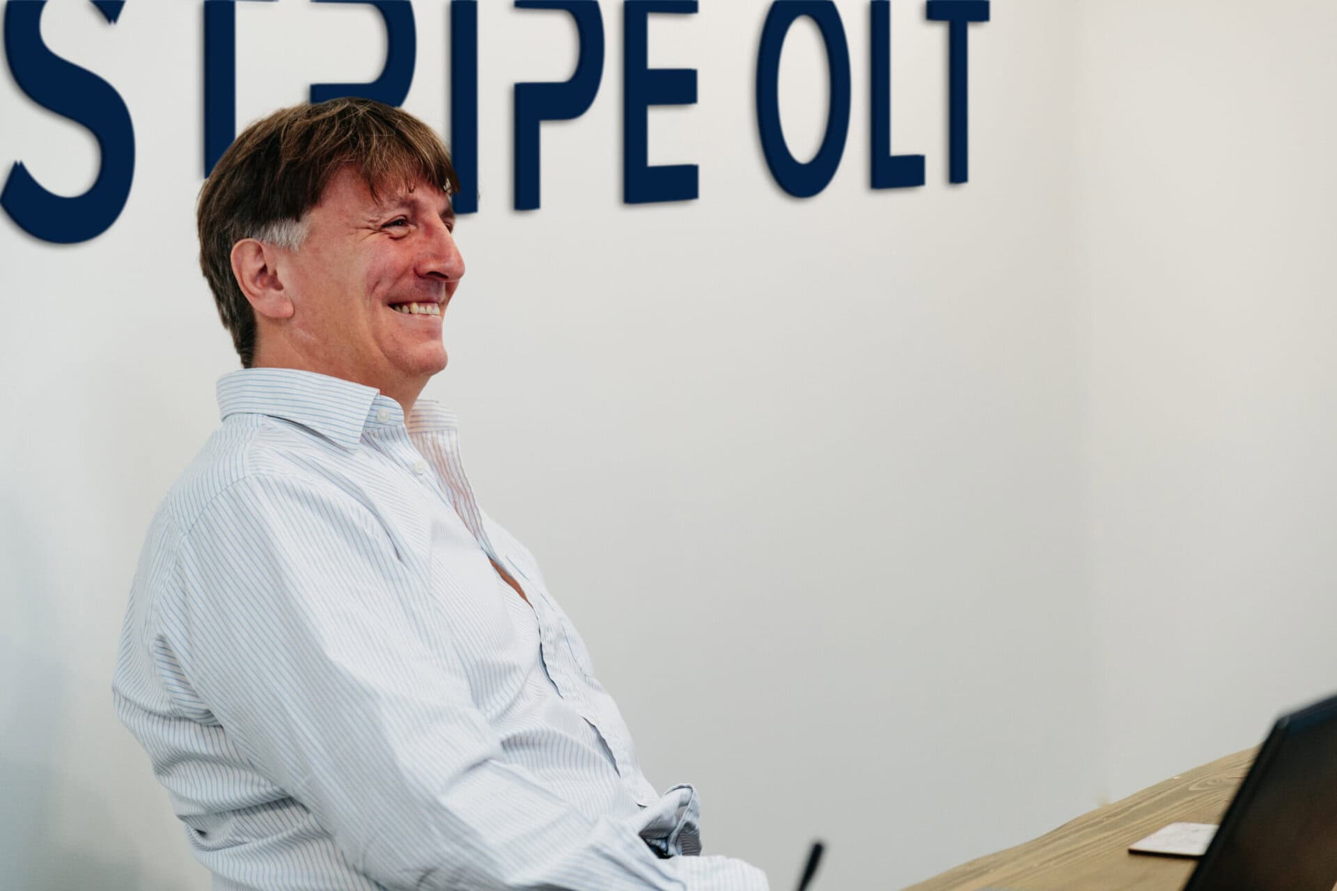 Person smiling while seated at a desk in an office environment